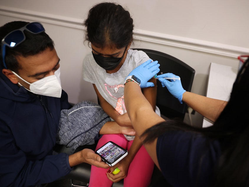 caption: A child receives the Pfizer BioNTech vaccine at the Fairfax County Government Center in Annandale, Va., last November. Vaccines will soon be available for children as young as 6 months old.