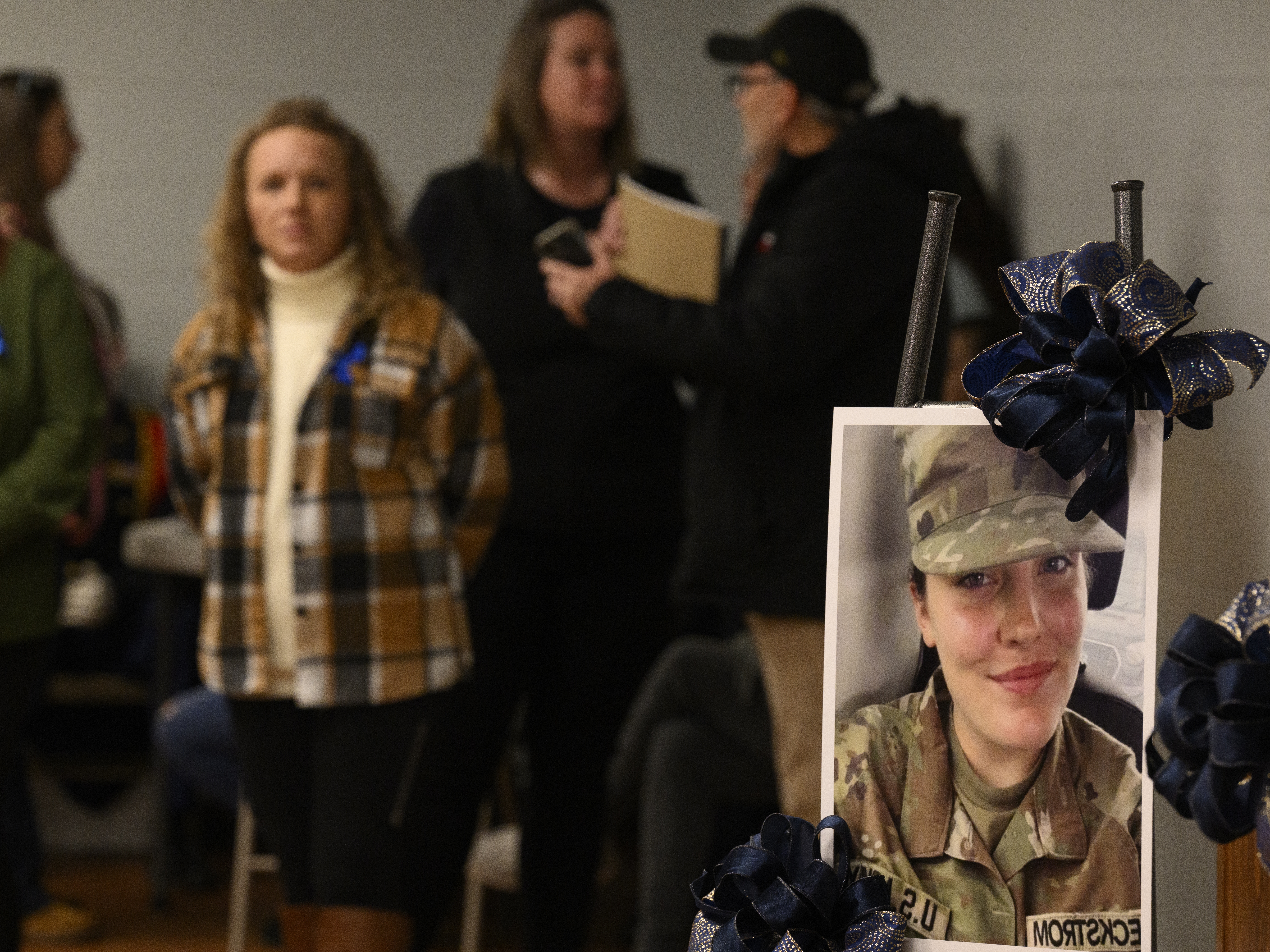 caption: Community members prepare a portrait of West Virginia National Guard Specialist Sarah Beckstrom for a vigil in her honor at the town hall on Friday in Webster Springs, W.Va.