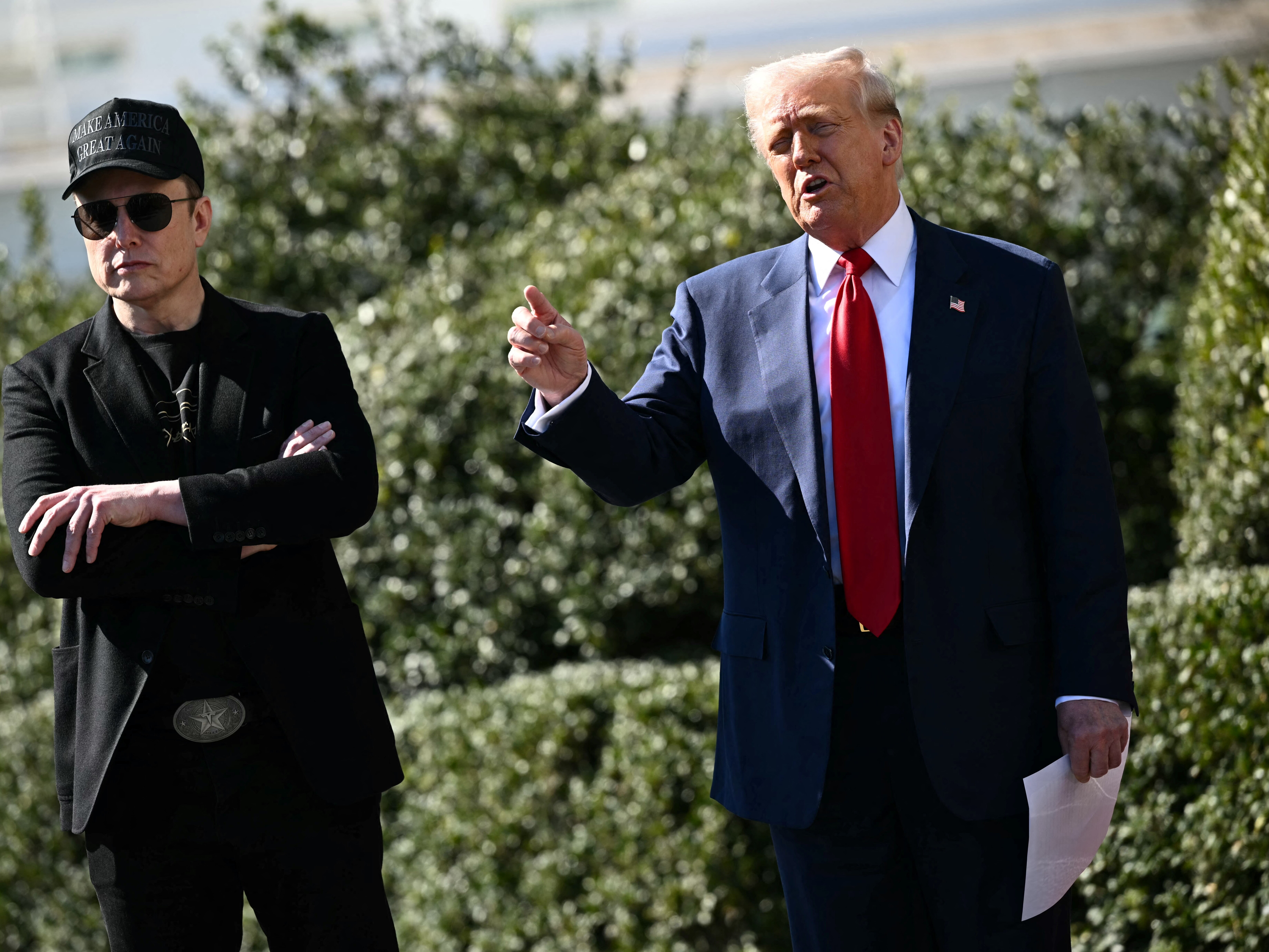 caption: President Trump and his adviser Elon Musk speak to the press on March 11 in Washington, D.C.
