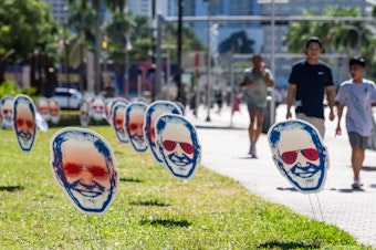caption: 1,000 "Dark Brandon" signs were placed around Miami ahead of the third Republican Debate in Miami last November.