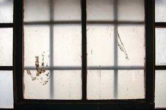 caption: A handprint stained on the window at the Navajo Nation Detention in Shiprock, N.M., on April 13, 2021.