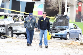 caption: Officials on the scene of the crash.