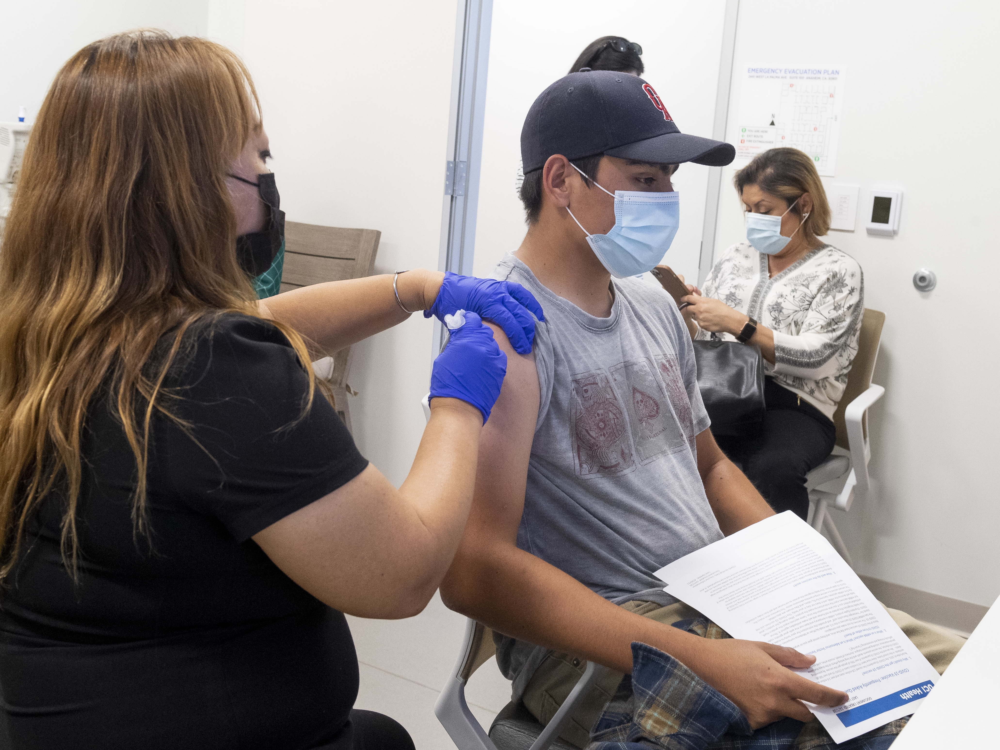 caption: This 16-year-old got his Pfizer-BioNTech COVID-19 shot late last month at the UCI Health Family Health Center in Anaheim, Calif. Students as young as 12 are now eligible to get the vaccine, too, the FDA says.