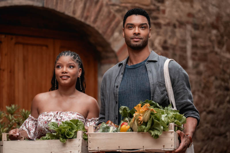 caption: Regé-Jean Page (right, photographed carrying a wooden crate, of course) and Halle Bailey star in "You, Me & Tuscany," which hits theaters April 10.
