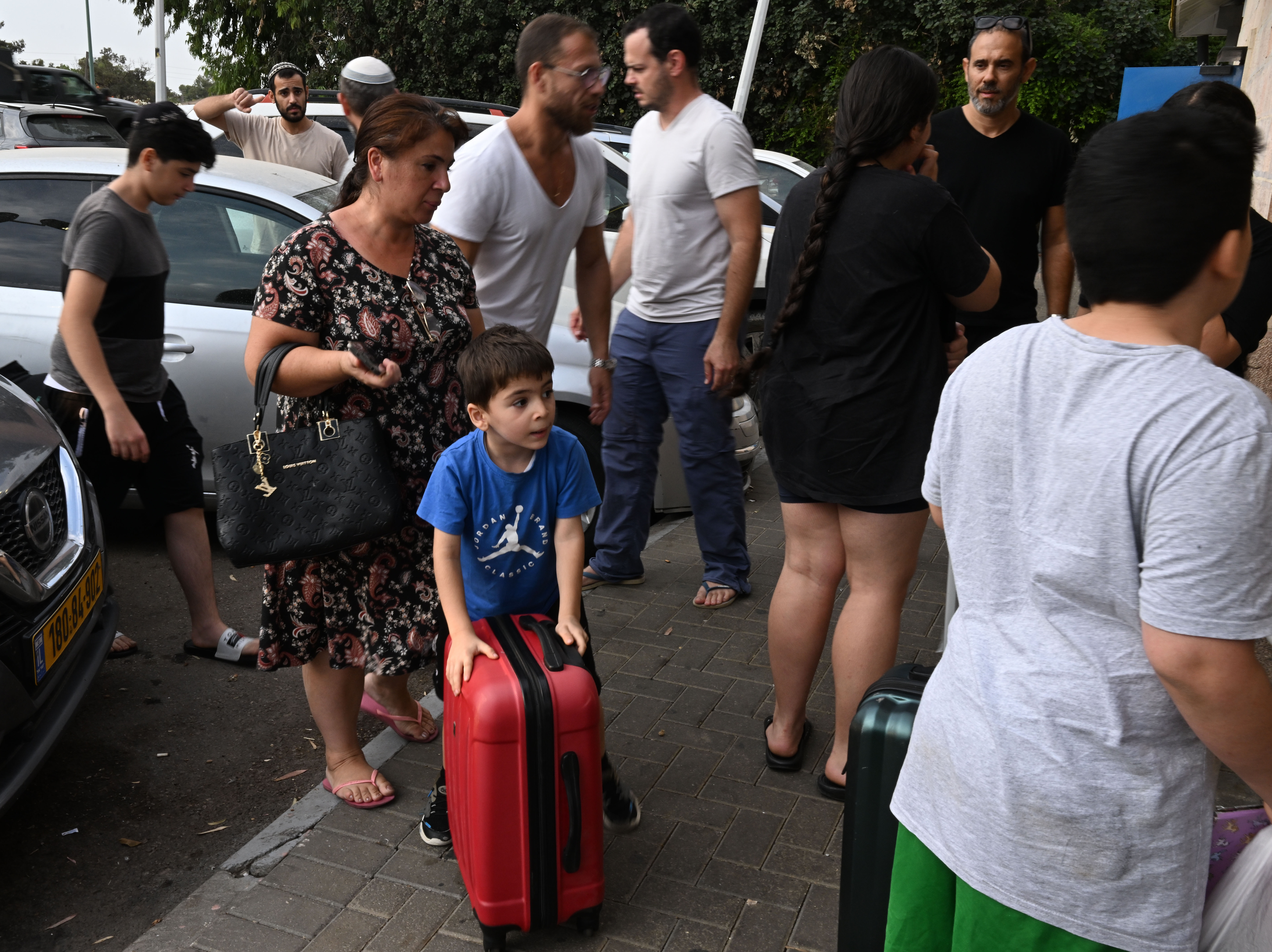 caption: A family of survivors is taken by volunteer drivers from their home.