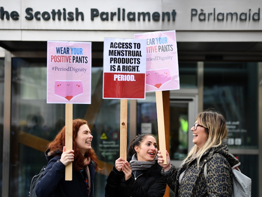caption: Activists rally outside the Scottish Parliament in Edinburgh in February in support of legislation for free period products. Scotland will make these products free to all who need them after lawmakers unanimously passed a bill that will require tampons and pads to be available in public places.