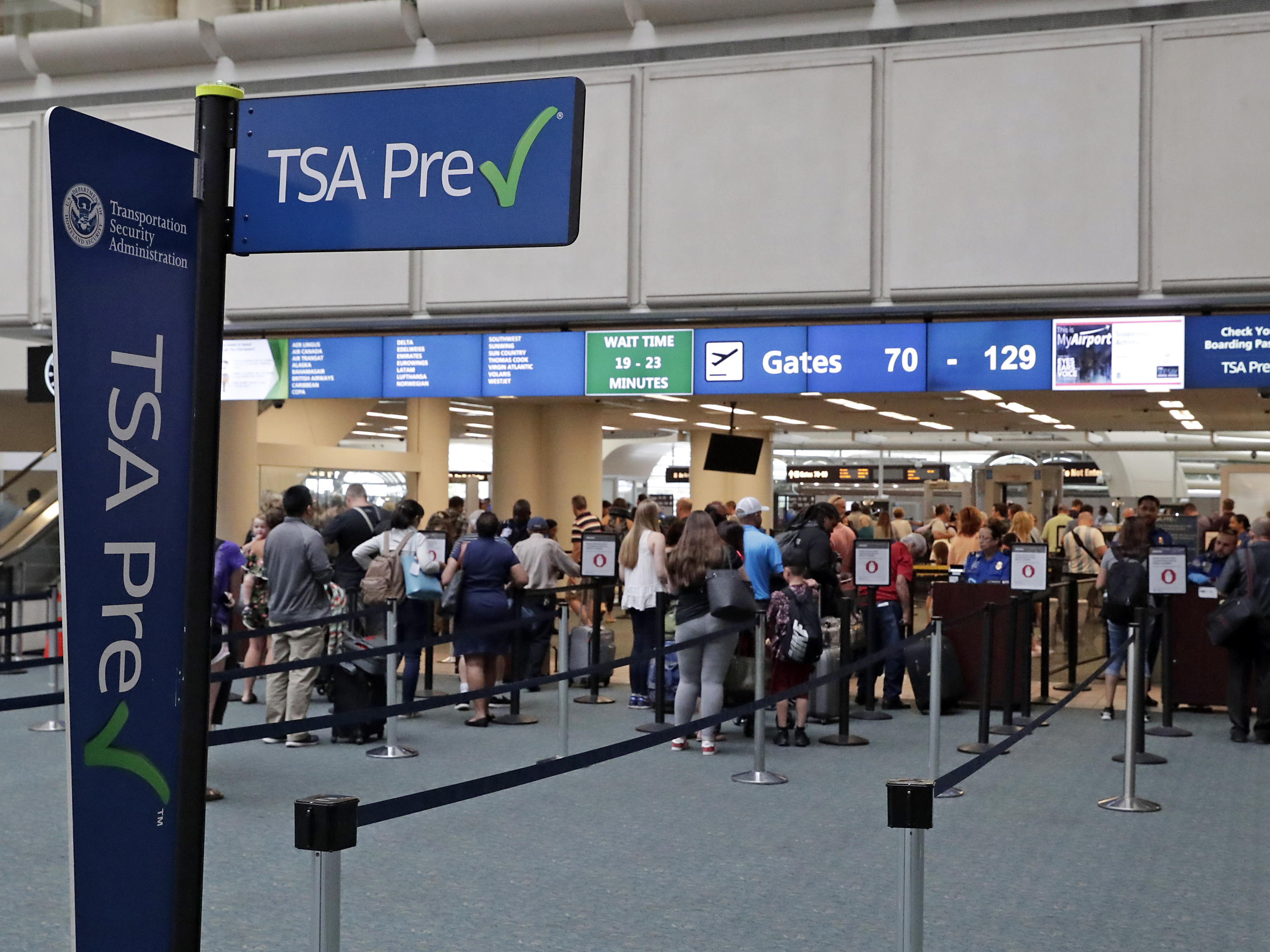 caption: Air passengers heading to their departure gates enter TSA PreCheck at Orlando International Airport. Access to PreCheck could now be revoked for unruly passengers.