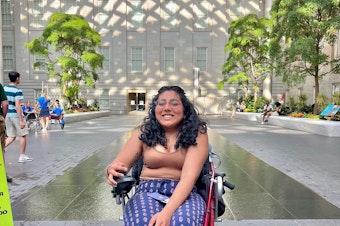 caption: Shruti Rajkumar sitting in a wheelchair at a museum in Washington, D.C.