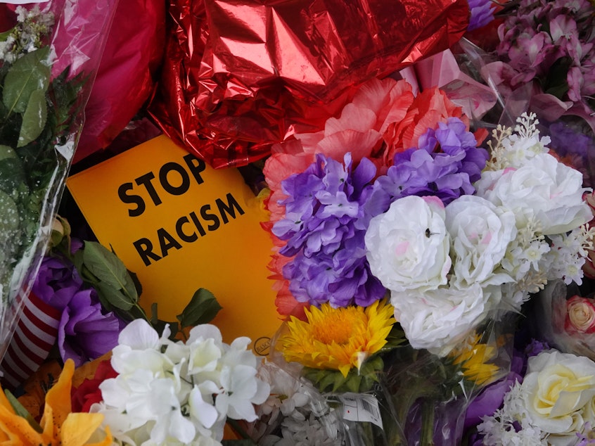 caption: Flowers, candles and mementoes are left at a makeshift memorial outside the Tops market on May 18, 2022 in Buffalo, New York. Police say the shooting that killed 10 and wounded three is being investigated as a racially motivated hate crime.