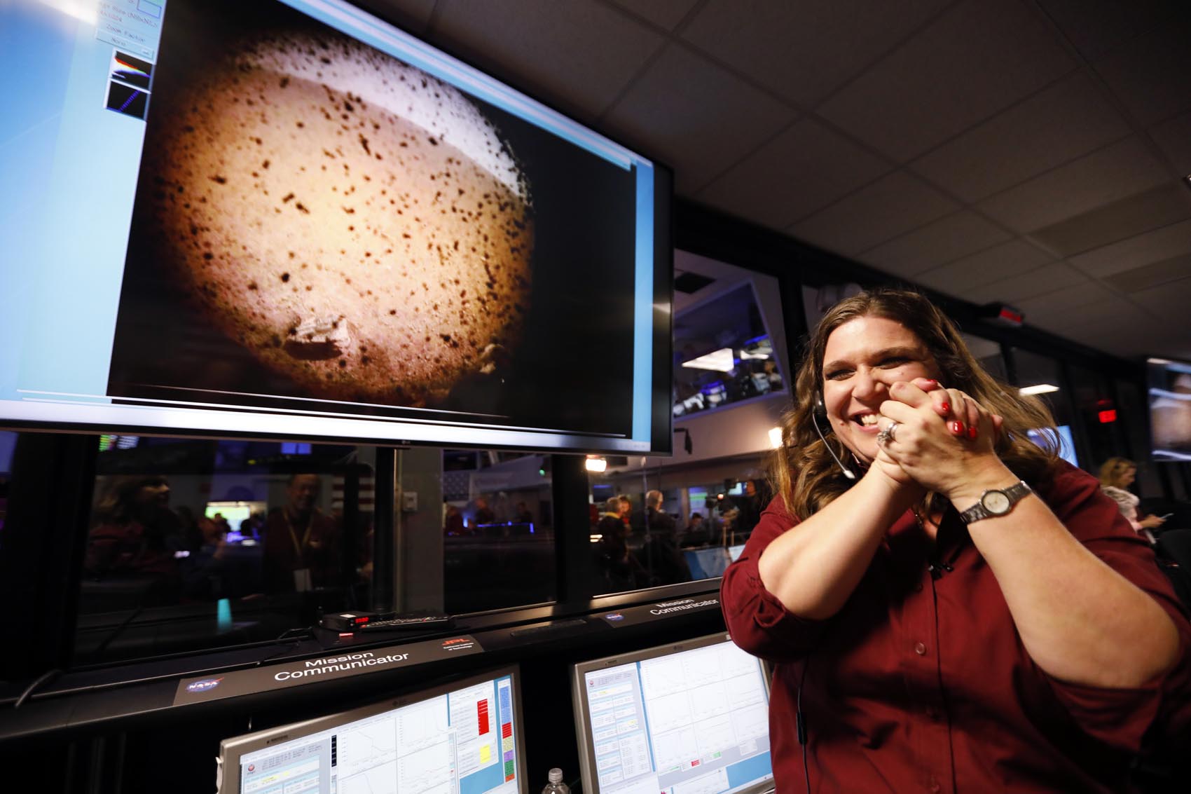 caption: An engineer smiles next to an image of Mars sent from the InSight Lander shortly after it landed on Mars in the mission support area of the space flight operation facility at NASA's Jet Propulsion Laboratory Monday, Nov. 26, 2018, in Pasadena, Calif. (Al Seib/Los Angeles Times via AP, Pool)