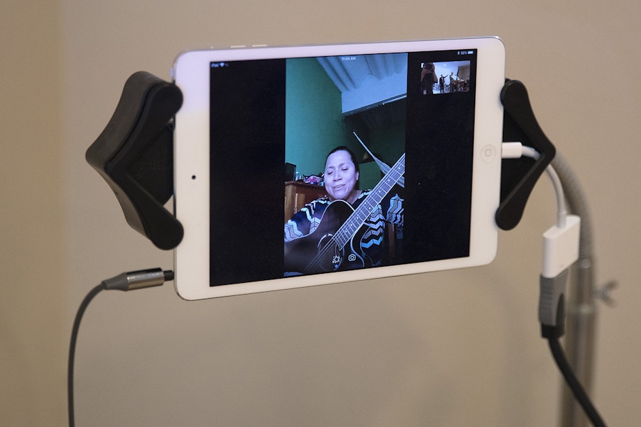 caption: : Reina Aquino Montejo sings through Skype during a church service in the basement of Nathan Robert's home, on Sunday, September 16, 2018, in Des Moines.