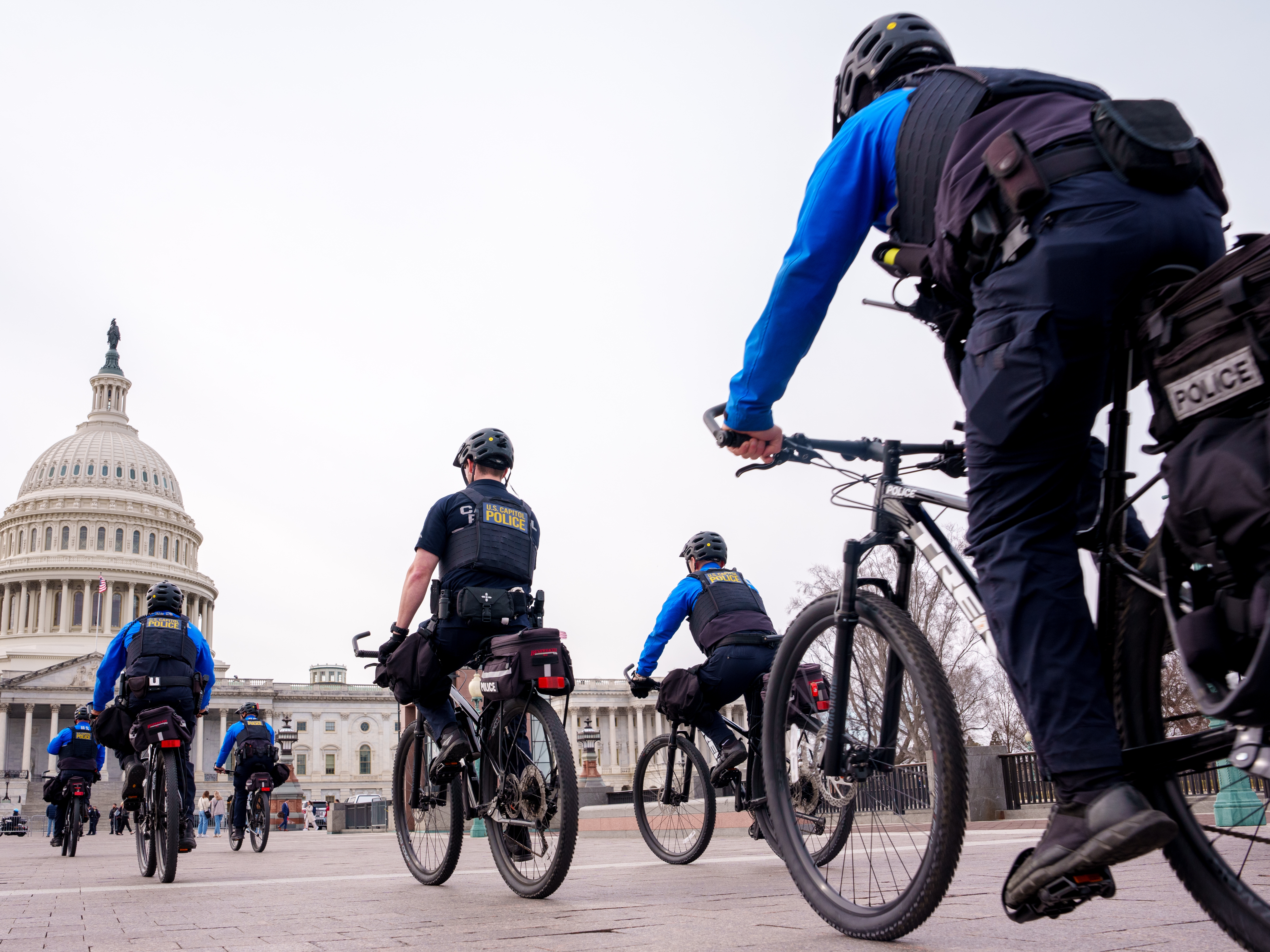 caption: WASHINGTON, DC - MARCH 4: The Dome of the U.S. Capitol Building is visible as U.S. Capitol Police bicycle along the East Front of the U.S. Capitol Building on March 4, 2025 in Washington, D.C.