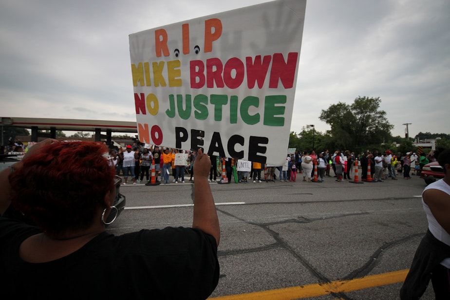 caption: A protester of the shooting of Michael Brown in Ferguson, Missouri, holds up a sign reading "No justice, no peace" -- a popular slogan.