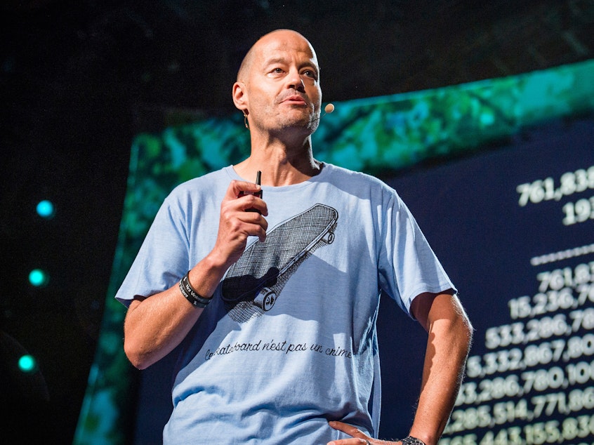 caption: Adam Spencer on the TED stage.