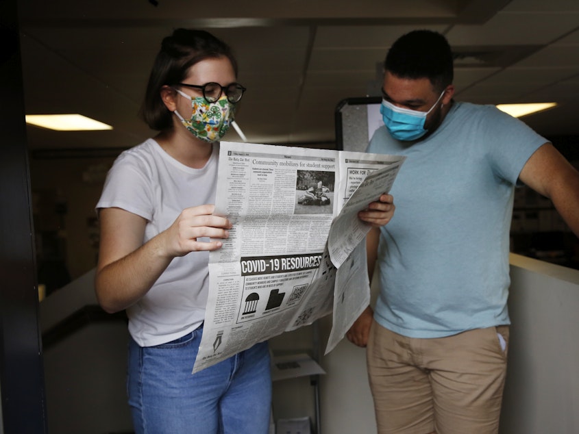 caption: Student journalists Anna Pogarcic and Brandon Standley of UNC's <em>Daily Tar Heel</em> review a recent issue at their offices off campus.