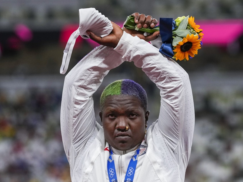 caption: Team USA's Raven Saunders with her silver medal in the women's shot put event Sunday at the Tokyo Olympics. During the medal ceremony, Saunders lifted her arms above her head and formed an "X' with her wrists.