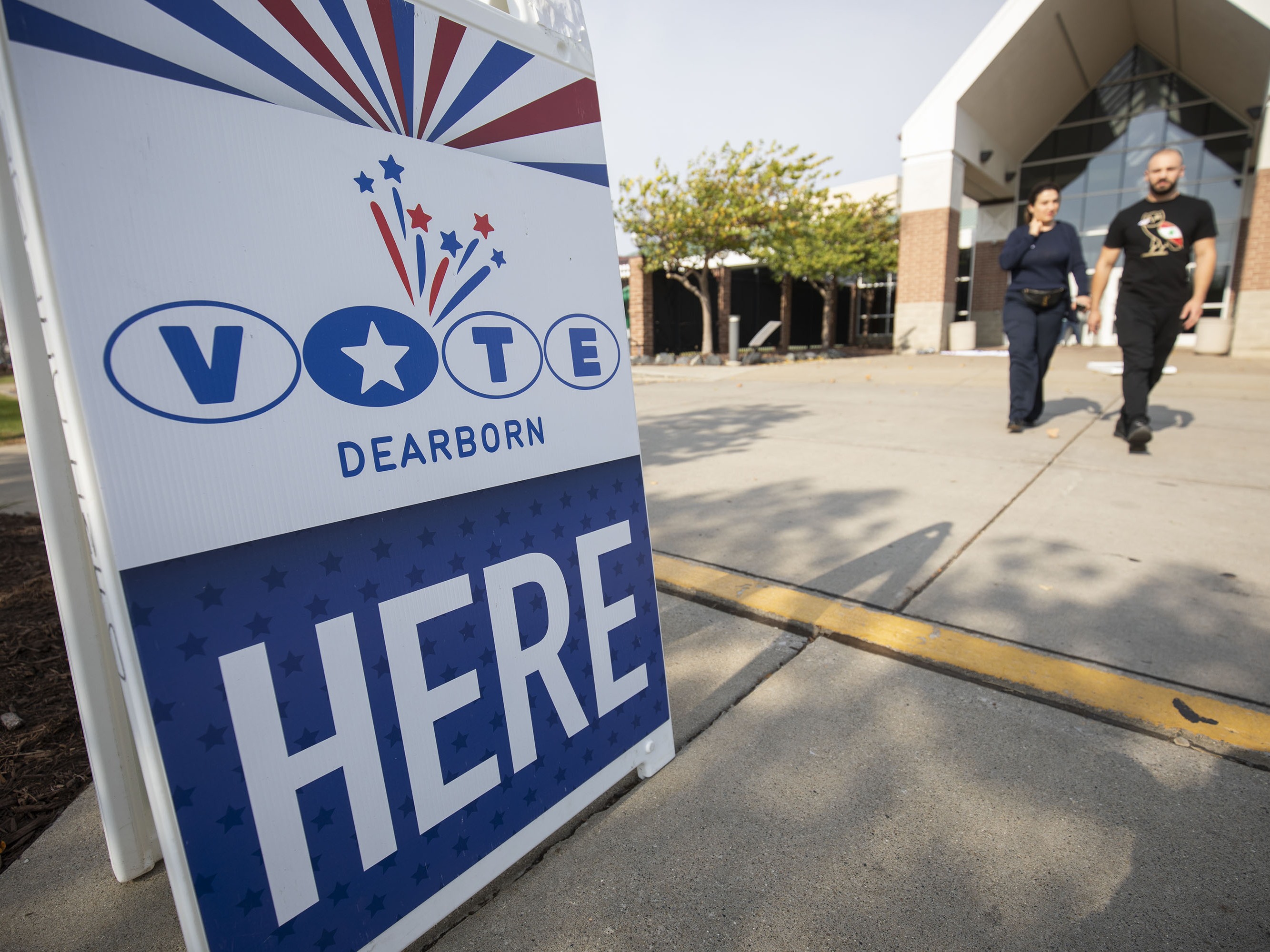 caption: People leave a polling place where voters are casting their ballots during Michigan's early voting period on October 29, 2024 in Dearborn, Michigan.