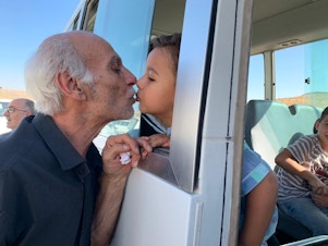 caption: Grandfather Issam kisses his grandson Rayan goodbye before the 4-year-old left to enter Iraq. Issam did not have papers to cross. "Separation has killed the people. It's destroyed a generation. War is without a purpose," Issam said, crying.