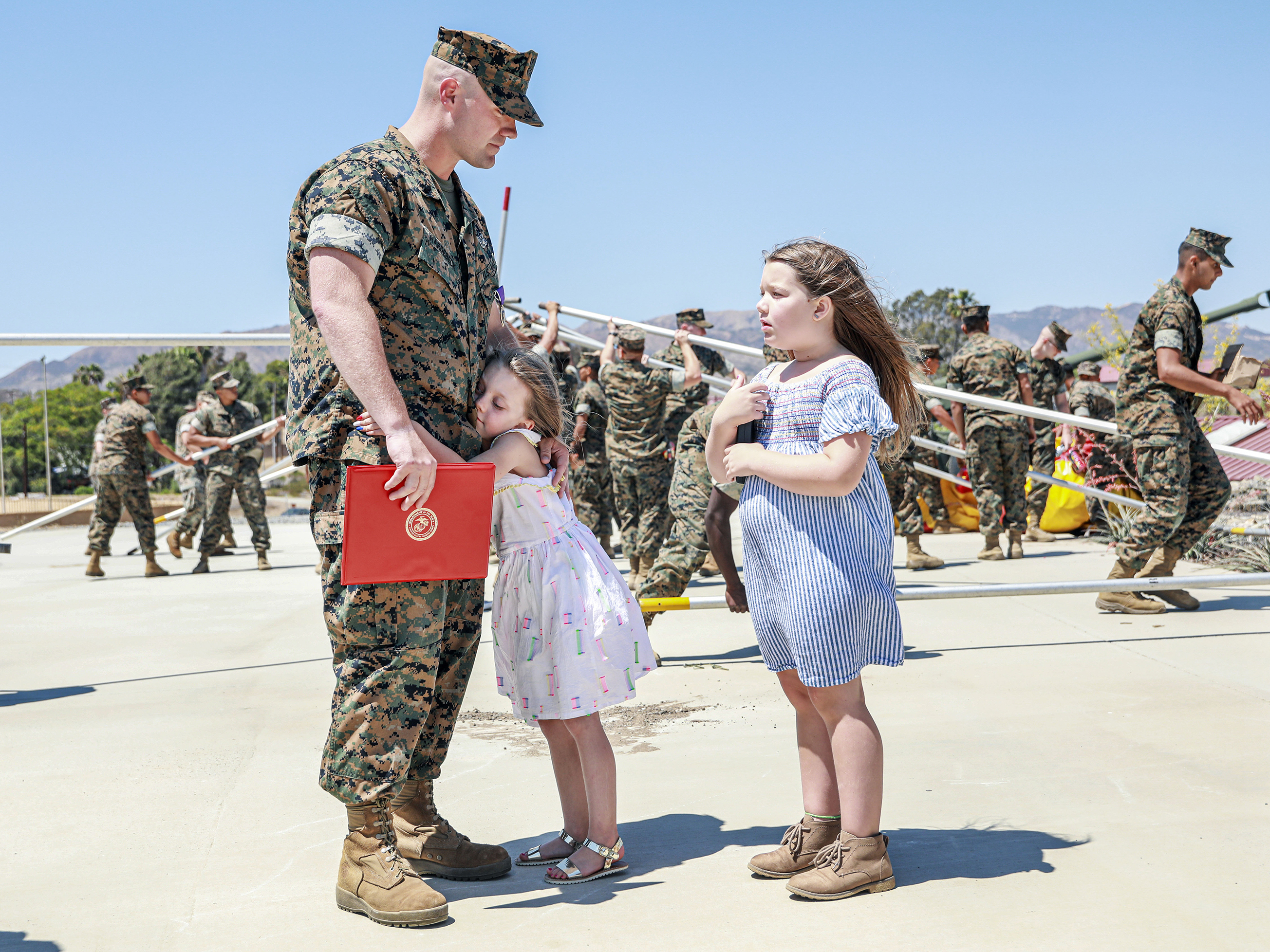 caption: Joseph Hardebeck, a senior Navy corpsman, is greeted by his daughters Zoey, 9, and Adalie, 7, after receiving the Purple Heart at an award ceremony at Southern California's Camp Pendleton on Thursday.