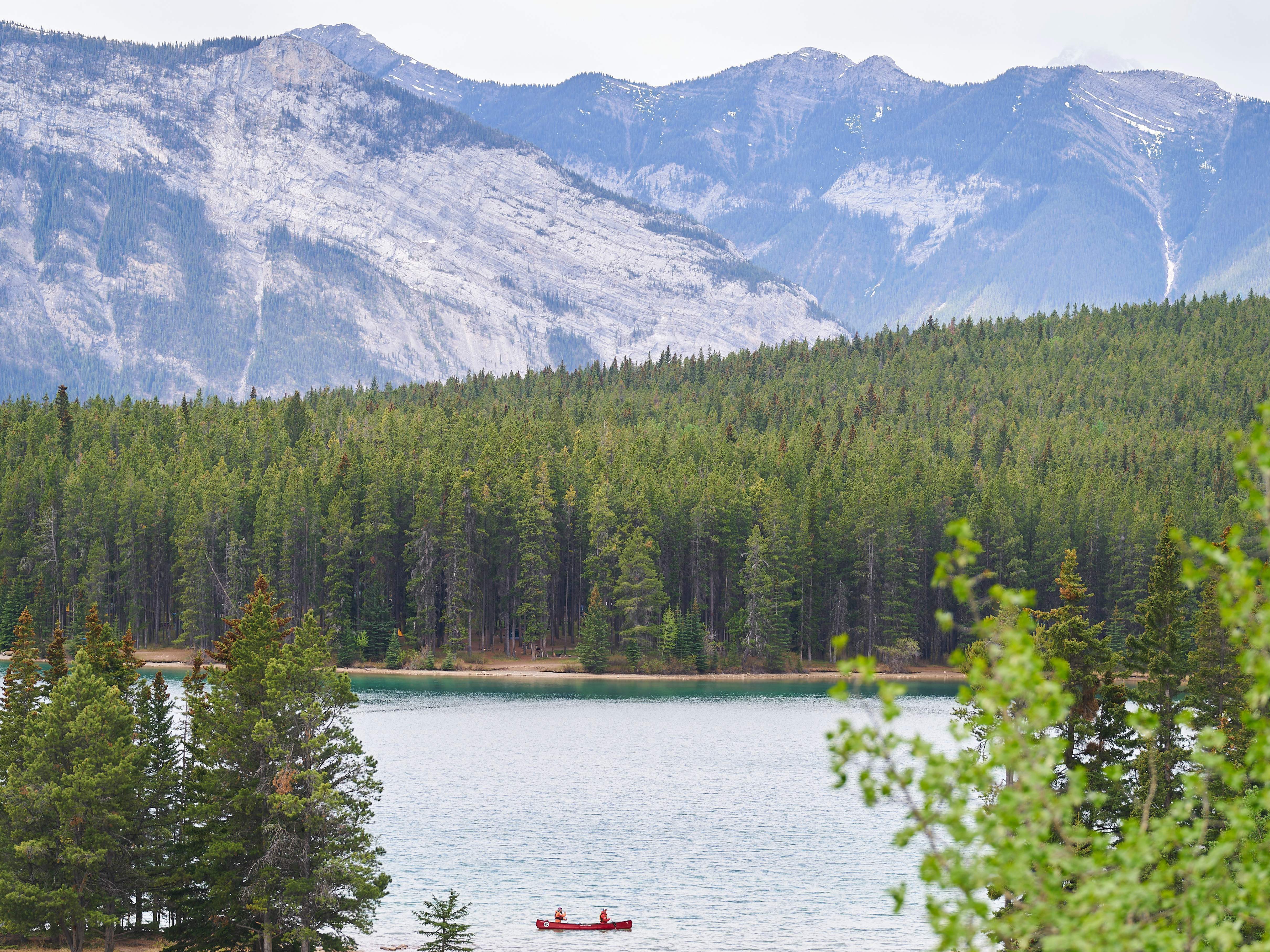 caption: Visitors canoe on Lake Minnewanka in Banff National Park in Banff, Alberta, Canada, on May 23, 2023.