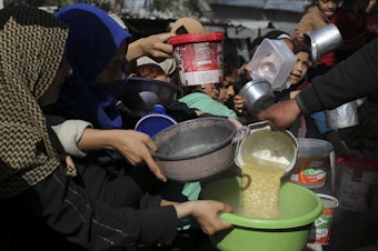 caption: Palestinians line up for a meal in Rafah on Wednesday.