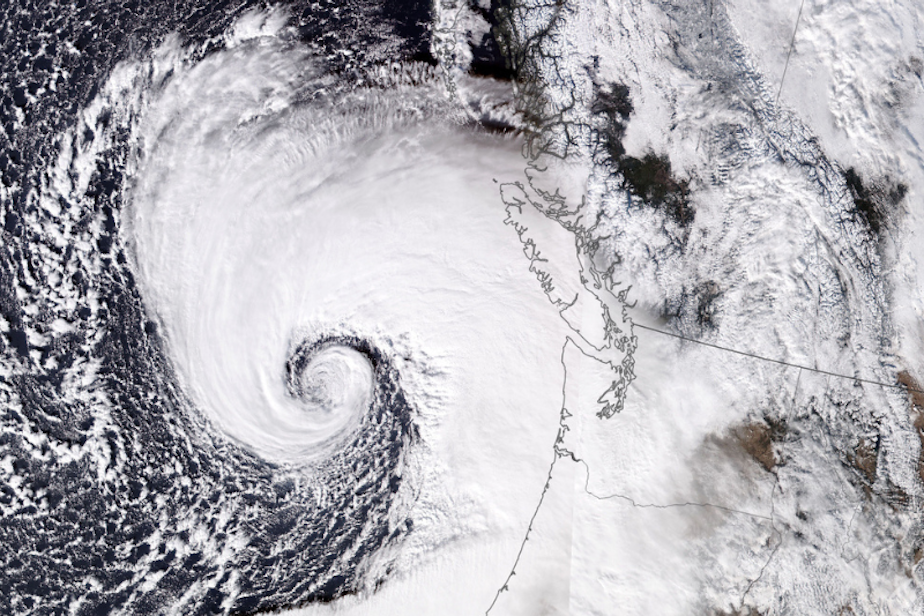 caption: This image taken by NASA shows a bomb cyclone over the Pacific Ocean, which sent heavy winds into Western Washington. The storm caused widespread power outages and property damage. Two people died from falling trees.