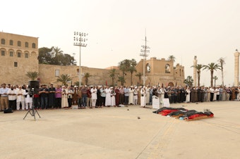 caption: Mourners gather for funeral prayers for fighters killed by warplanes of Khalifa Haftar's forces on April 24 in Tripoli, Libya.