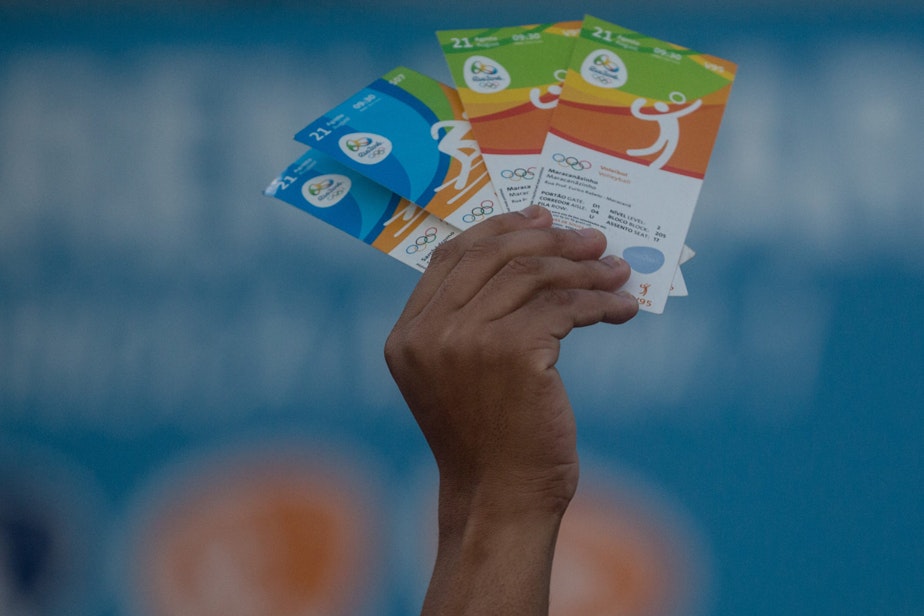 caption: A man holds up tickets to sell or swap outside a venue at the Rio 2016 Olympic Games on Aug. 19, 2016 in Rio de Janeiro, Brazil. (Chris McGrath/Getty Images)