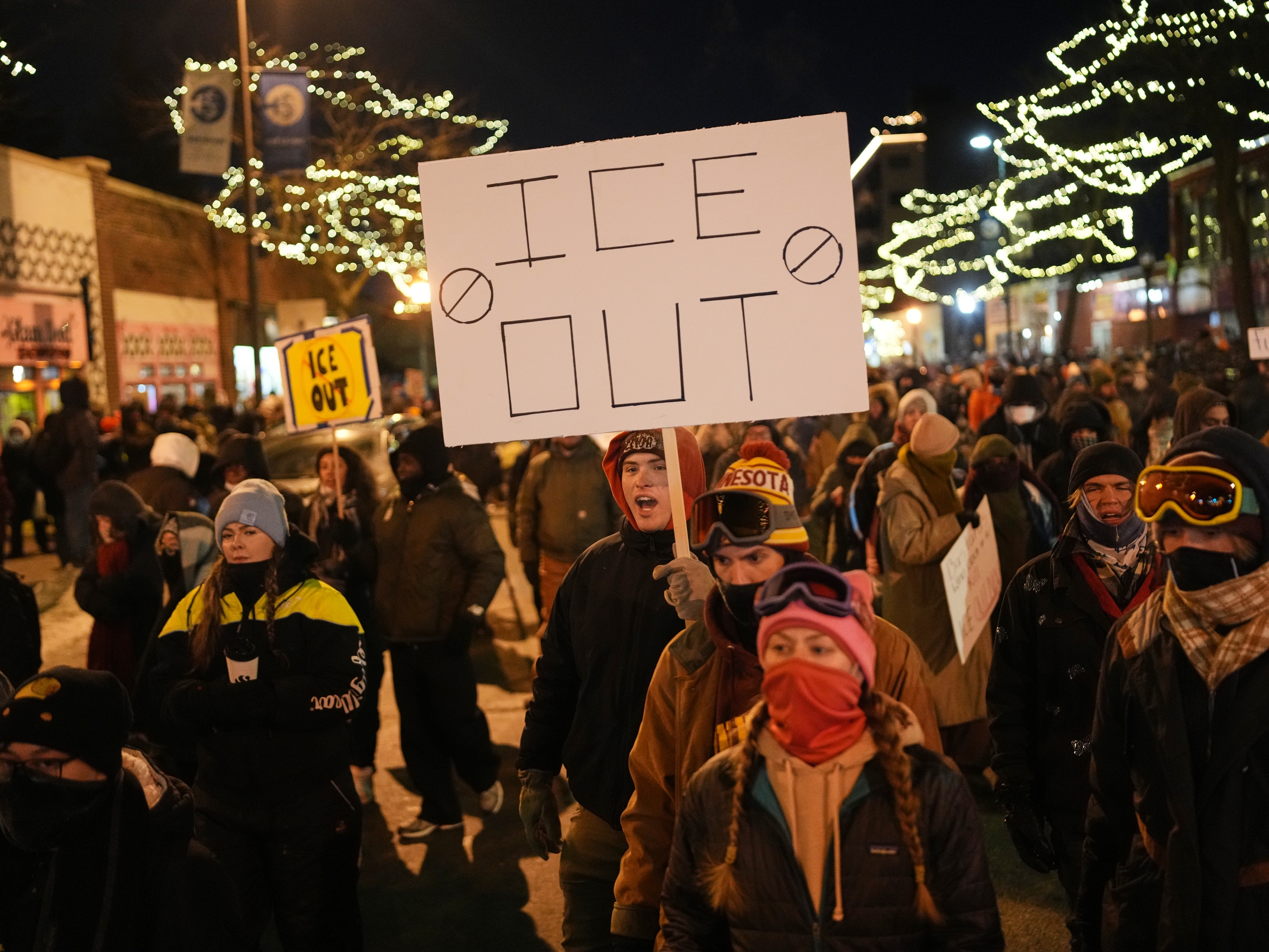 caption: A person holds a sign during a vigil for 37-year-old Alex Pretti, who was fatally shot by a U.S. Border Patrol officer earlier in the day, Saturday, Jan. 24, 2026, in Minneapolis. (AP Photo/Adam Gray)