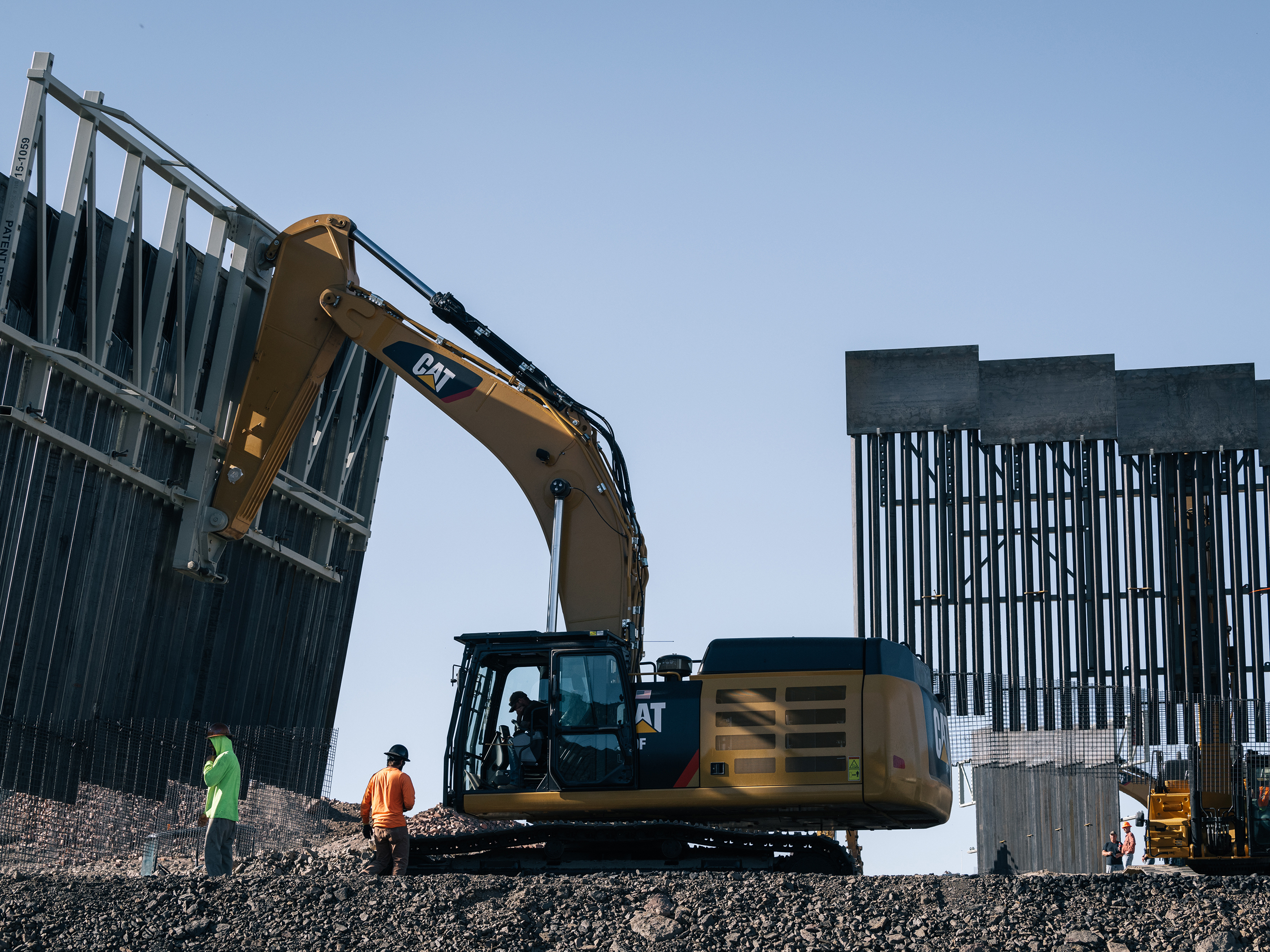caption: Fisher Industries workers move sections on May 24, 2019 in Sunland Park, N.M., near International Boundary Monument No. 1 where New Mexico, Texas and Mexico come together.