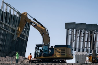 caption: Fisher Industries workers move sections on May 24, 2019 in Sunland Park, N.M., near International Boundary Monument No. 1 where New Mexico, Texas and Mexico come together.