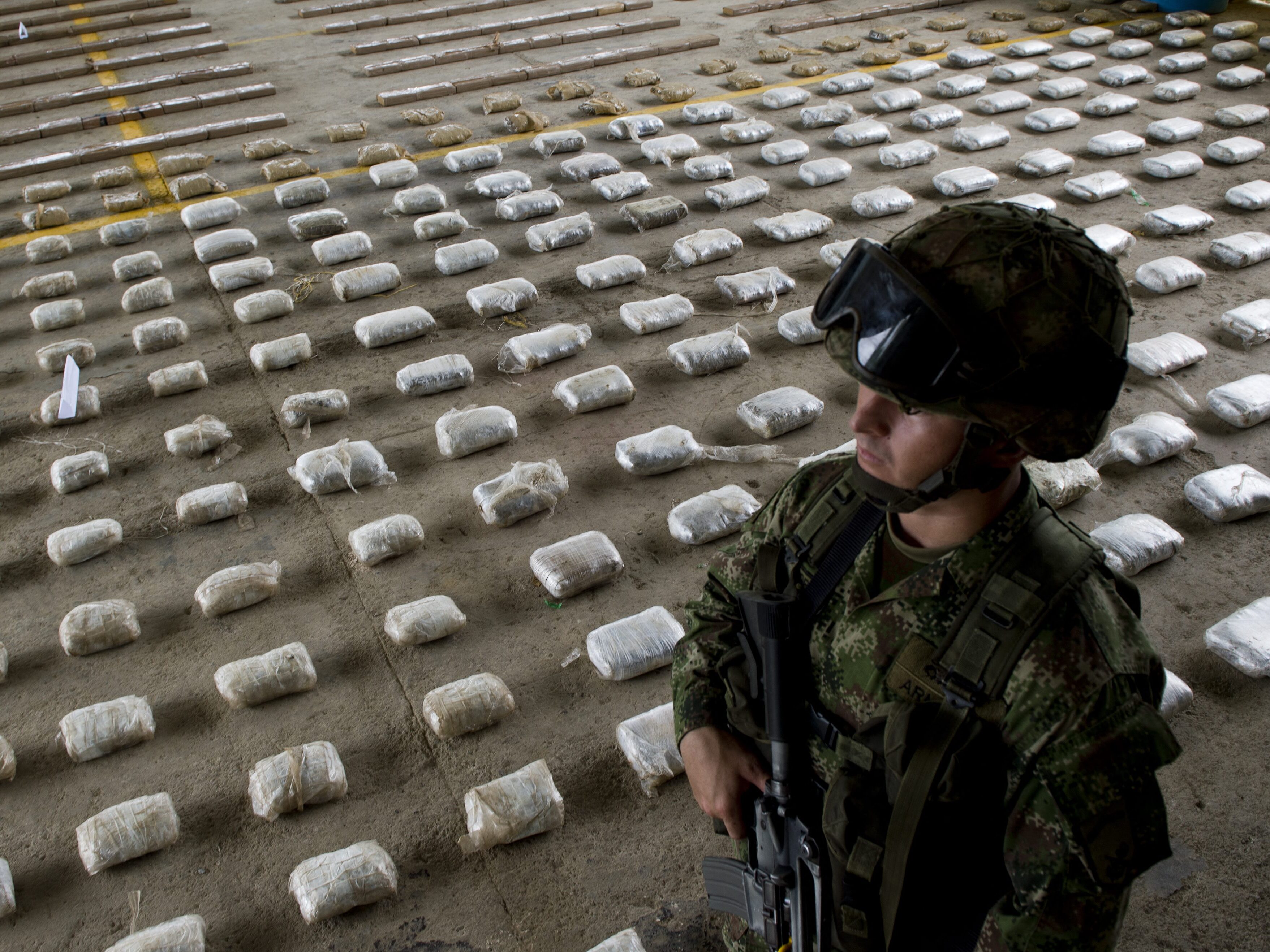 caption: A Colombian Army soldier stands next to packages of seized cocaine during a press conference at a Military Base in Bahia Solano, department of Choco, Colombia, on March 14, 2015.