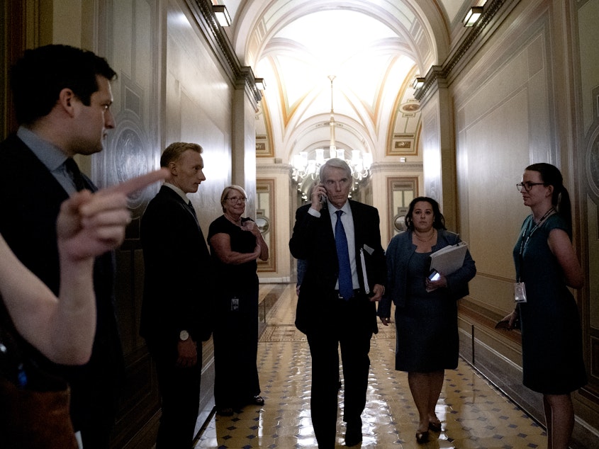 caption: Sen. Rob Portman, R-Ohio, center, arrives to a bipartisan infrastructure meeting at the U.S. Capitol on Wednesday.