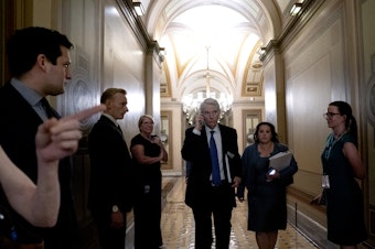 caption: Sen. Rob Portman, R-Ohio, center, arrives to a bipartisan infrastructure meeting at the U.S. Capitol on Wednesday.