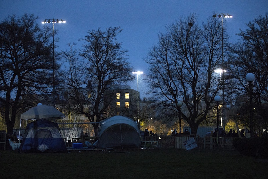 caption: The barricaded encampment of unhoused community members is shown moments before Seattle police officers cleared the area on Friday, December 18, 2020, at Cal Anderson Park in Seattle. 