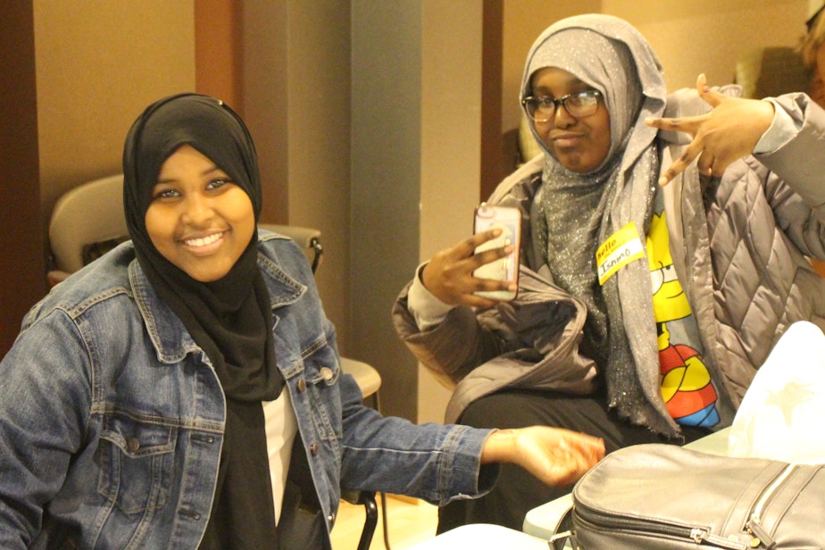 caption: Coalition for Refugees from Burma participants Aisha Abdirizak and Isnino Ahmed writing their script at KUOW.
