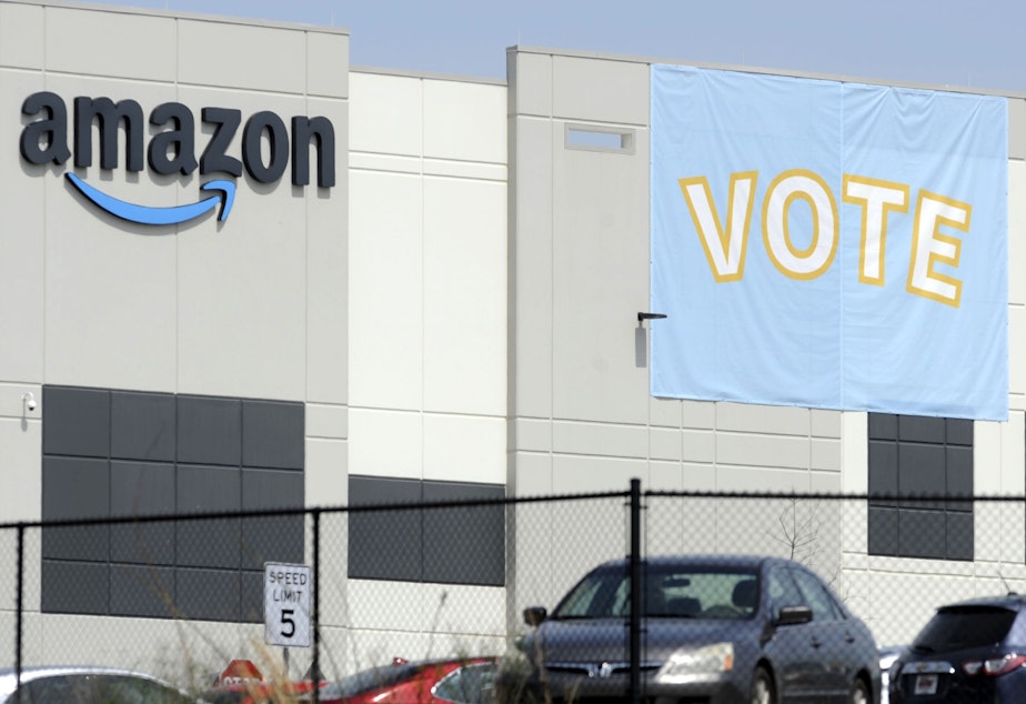 caption: A banner encourages workers to vote in a union election at Amazon's warehouse in Bessemer, Ala.