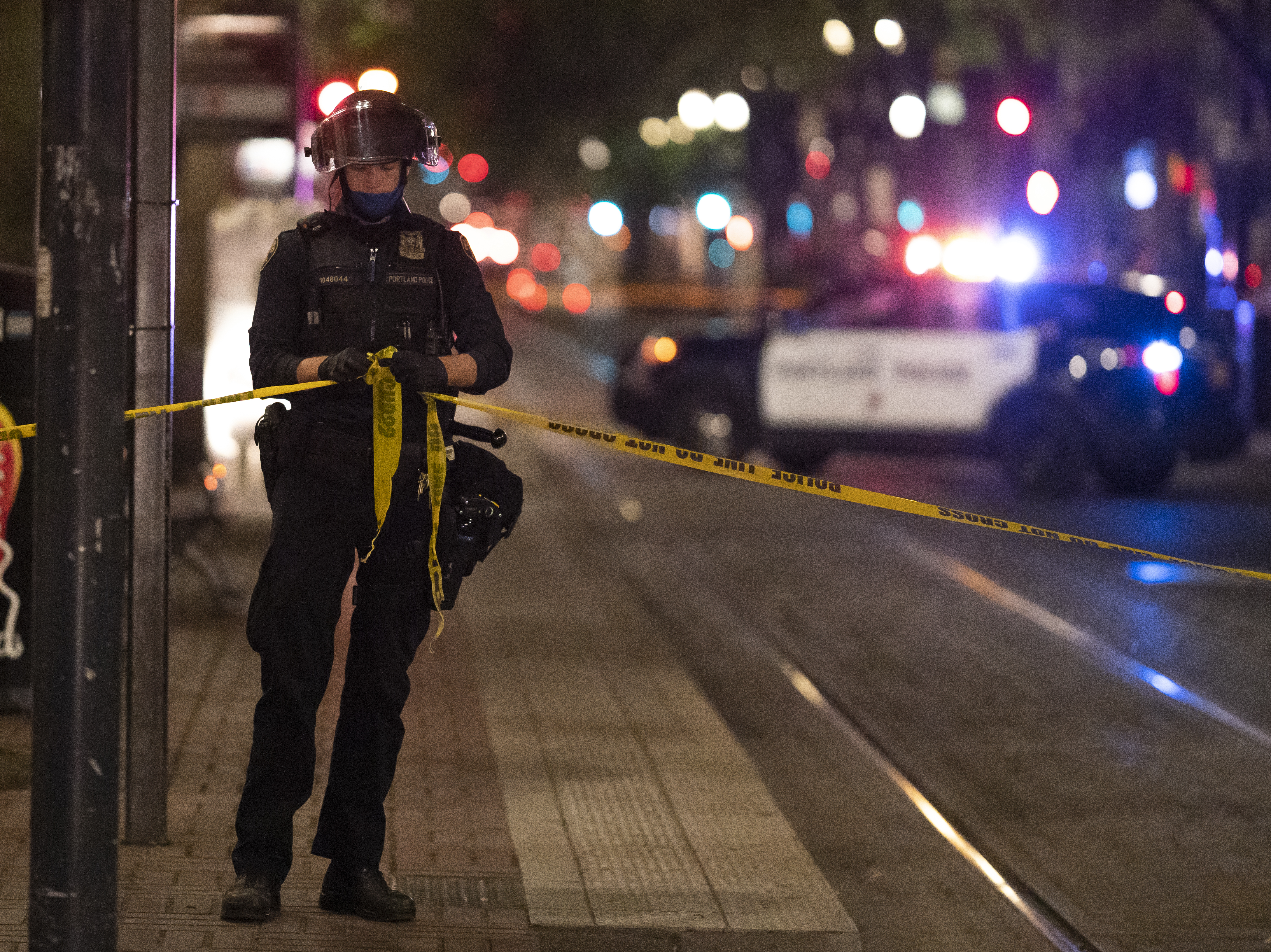 caption: A Portland police officer ties a police line around the scene of a fatal shooting in Portland Saturday. It's the latest incident after weeks of Trump supporters clashing with counterprotesters.