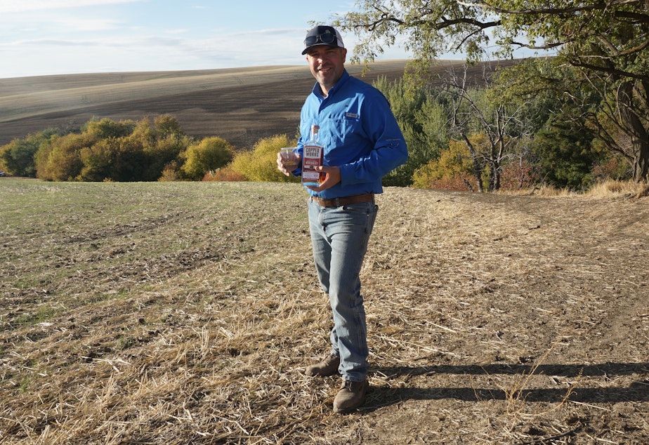 caption: Nathan Rea holds a bottle of the first Salmon-Safe American single malt whiskey. Rea grew the barley used to make the whiskey in Walla Walla.