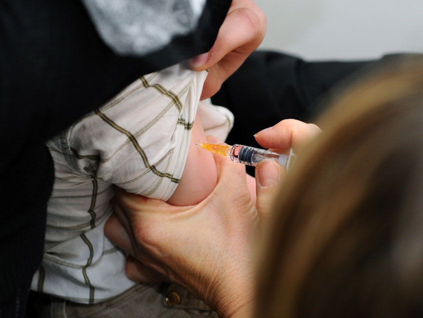 caption: A child is immunized against measles, mumps and rubella in Lyon, France.