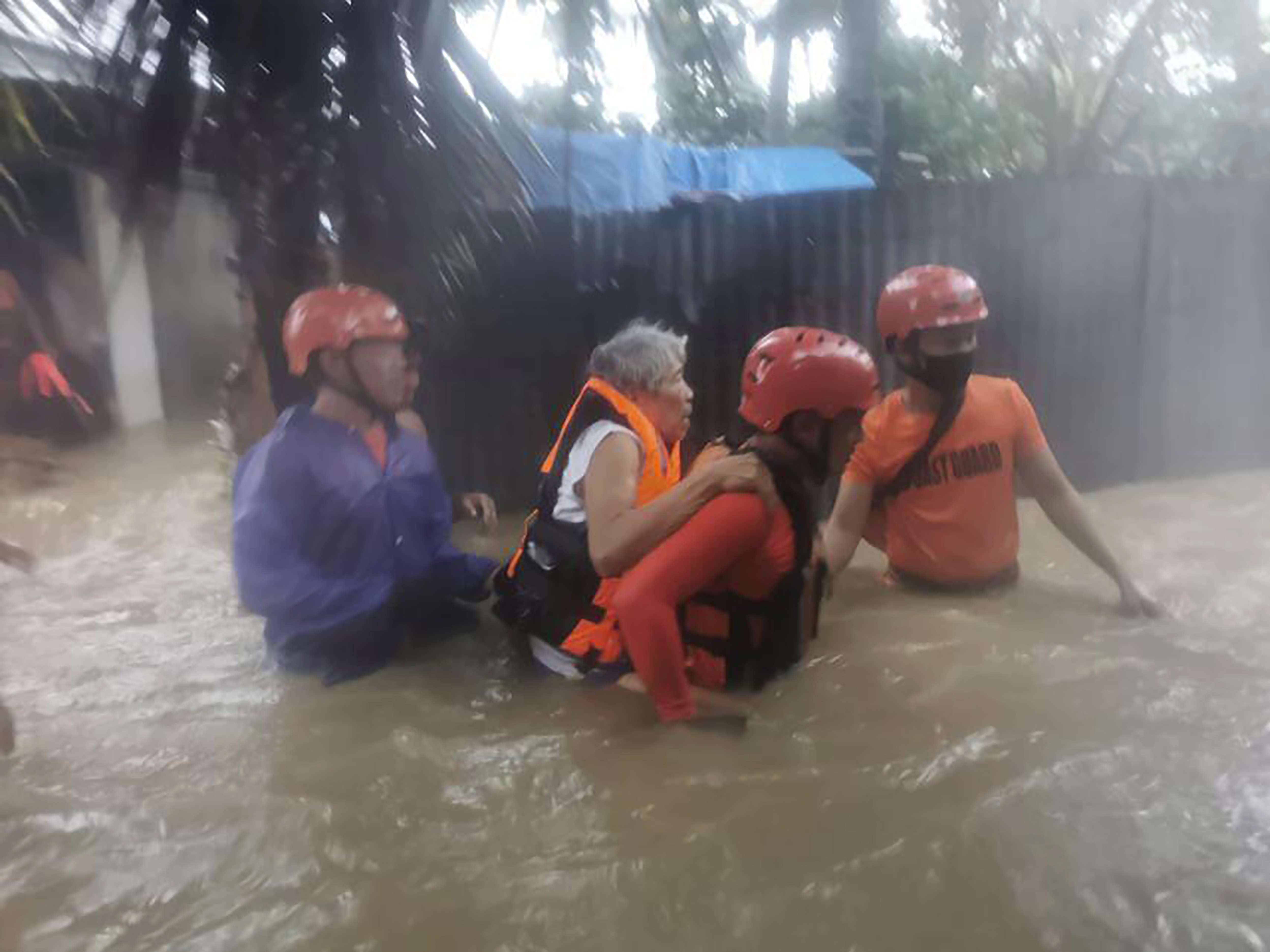 caption: Rescuers take residents to safer ground as floods caused by Tropical Storm Dante hit Maasin City in Southern Leyte province, central Philippines. The tropical storm has left at least a few people dead and displaced hundreds of people in the southern and central Philippines.