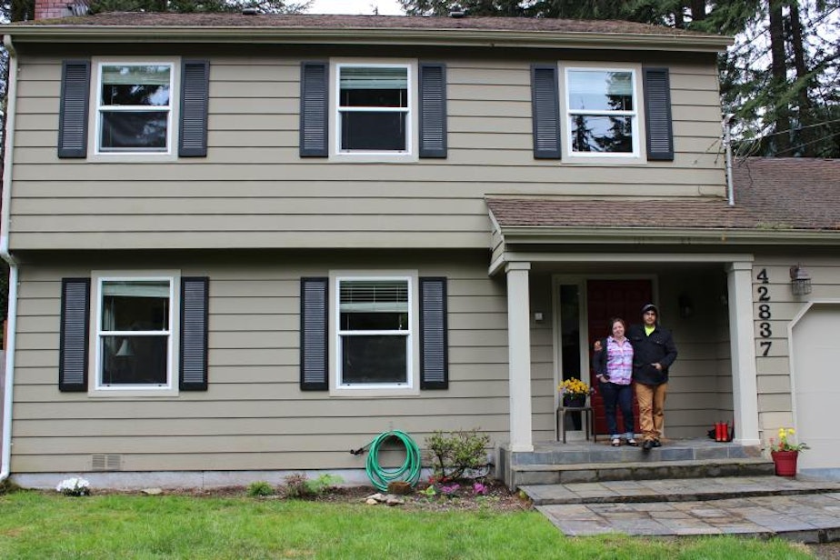 caption: Andrea VanHorn and her fiancee outside their three-bedroom home in North Bend, which she said is a lot more affordable than living in Seattle.