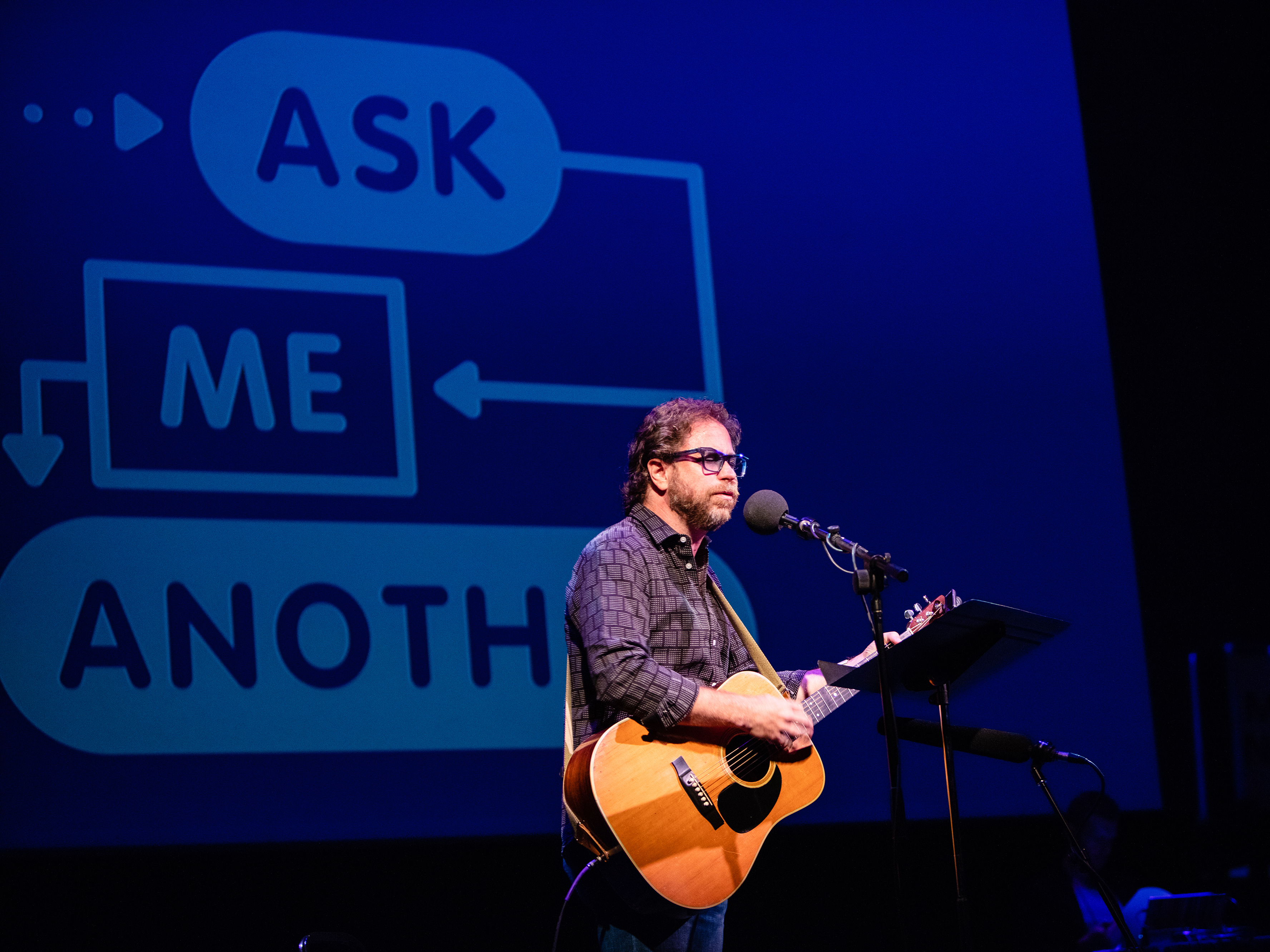 caption: <em>Ask Me Another</em>'s house musician Jonathan Coulton leads a music parody game at the Paramount Theatre in Austin, Texas.