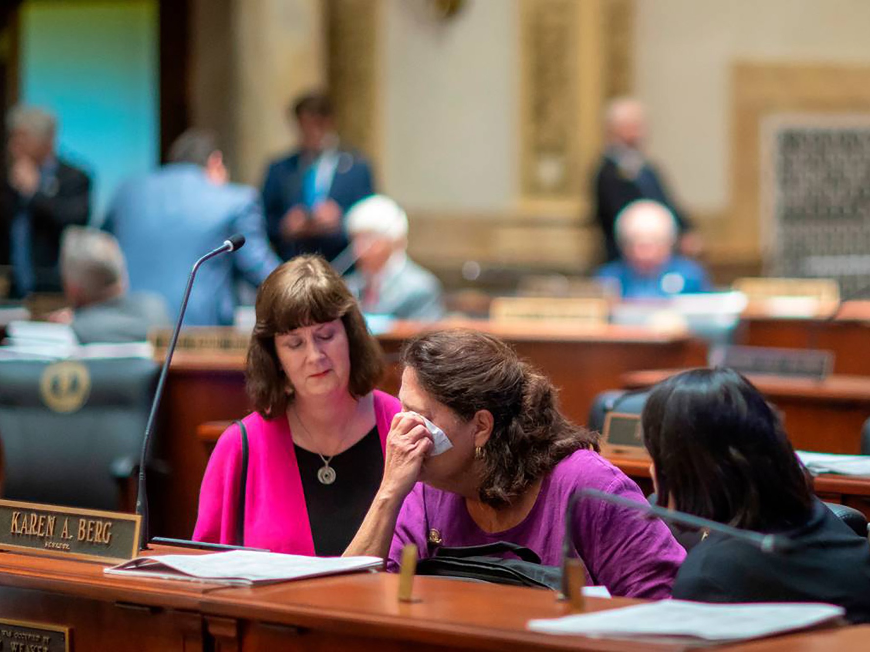 caption: Kentucky state Sen. Karen Berg (D-Louisville), is consoled by colleagues after SB 150 passed the Senate, 29-6, at the Kentucky state Capitol in Frankfort on Feb. 16, 2023. Berg's transgender son died by suicide in December 2022. 