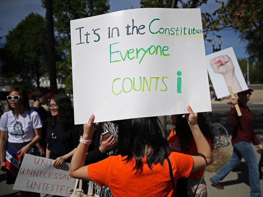 caption: Protesters gather outside the U.S. Supreme Court in April as the justices hear oral arguments over the citizenship question the Trump administration wants to add to the 2020 census.