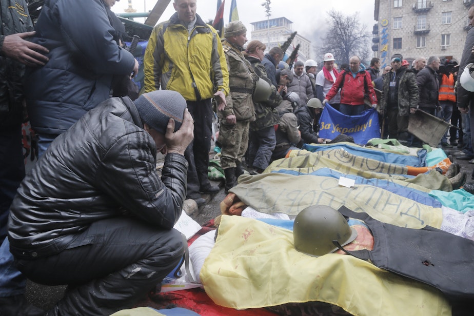 caption: Activists pay respects to protesters killed in clashes with police, during clashes with riot police in Kiev's Independence Square, the epicenter of the country's current unrest.