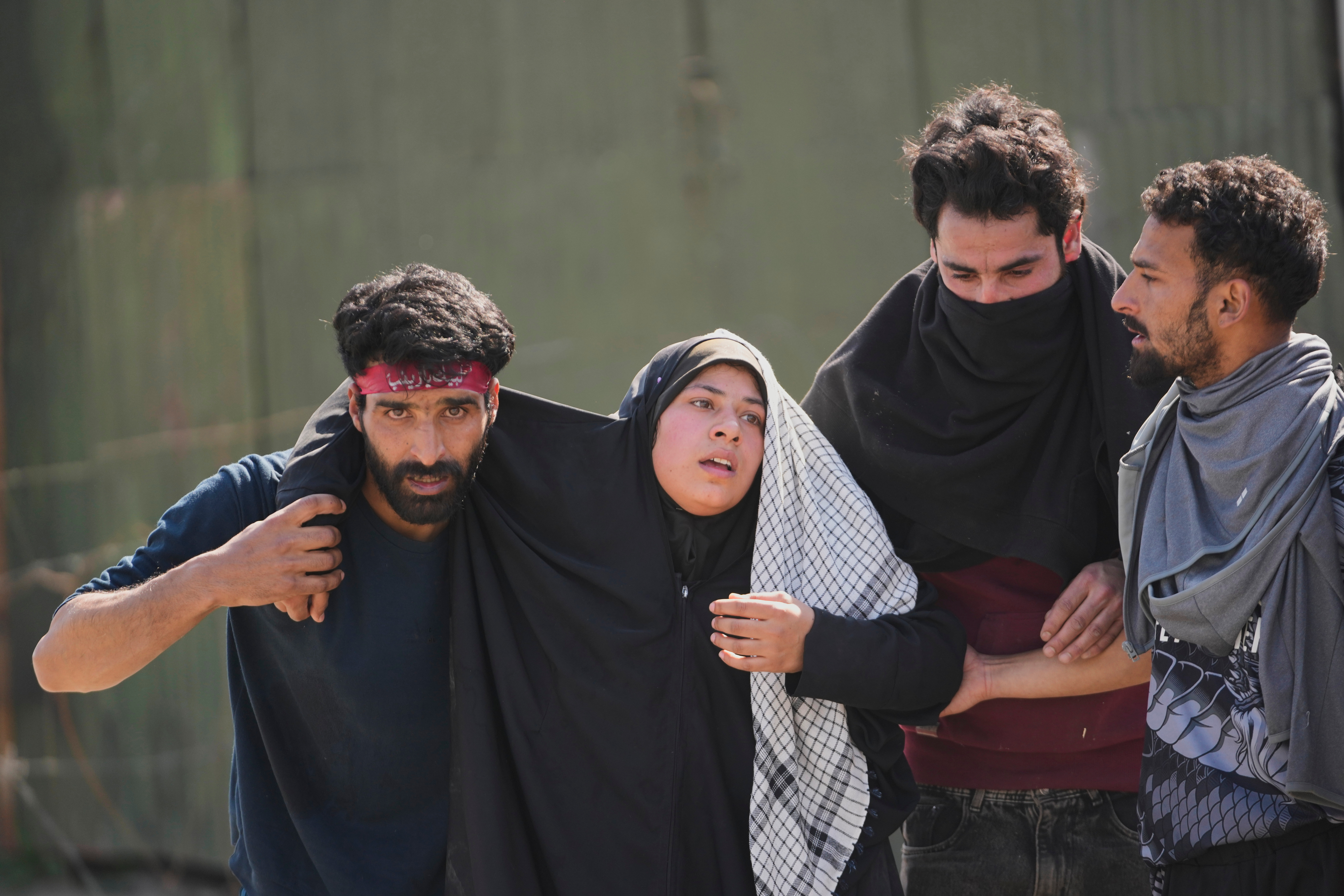 caption: An injured Shiite Muslim woman is taken to medical help during a protest against the killing of Iran's Supreme Leader Ayatollah Ali Khamenei, in Srinagar, Indian controlled Kashmir, Monday, March 2, 2026.