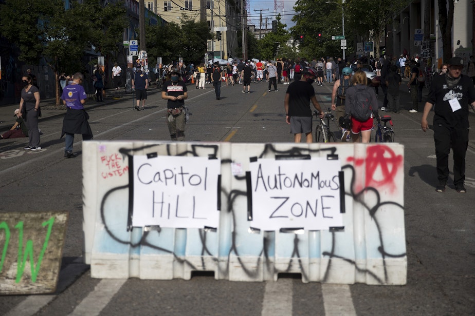 caption: Barriers are set up at the intersection of 11th Avenue and East Pine Street at the 'Capitol Hill Autonomous Zone,' also known as CHAZ, on Wednesday, June 10, 2020, in Seattle.
