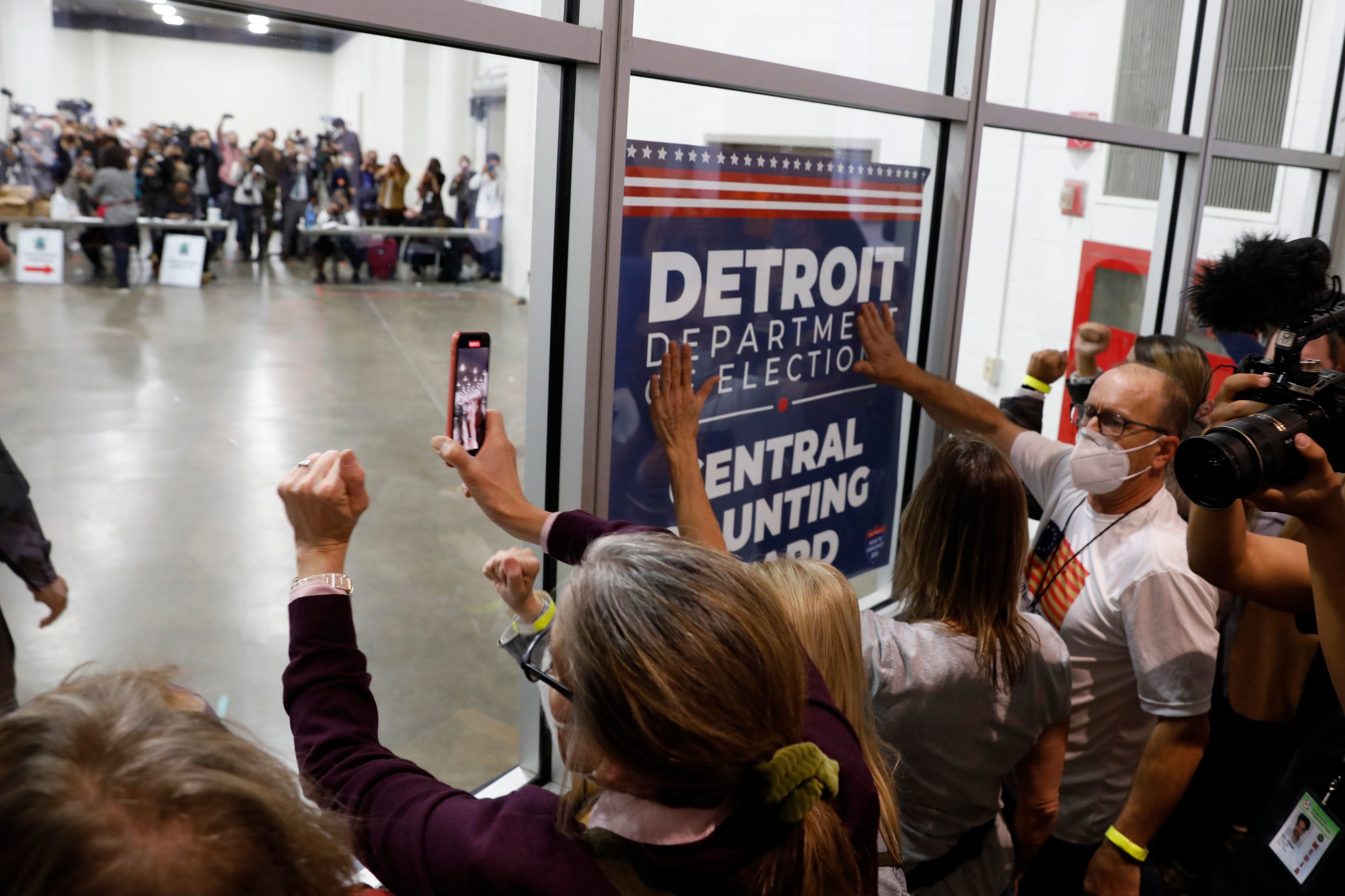 caption: Supporters of President Trump bang on the glass and chant slogans outside the room where absentee ballots for the 2020 general election are being counted at TCF Center on Nov. 4, 2020 in Detroit, Michigan. (Jeff Kowalsky/AFP via Getty Images)