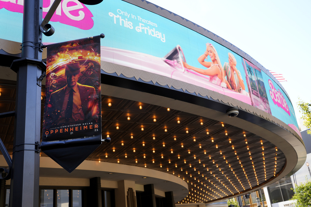 caption: Advertisements for the films "Oppenheimer" and "Barbie" appear at AMC Theaters at The Grove on Thursday, July 20, 2023, in Los Angeles. 